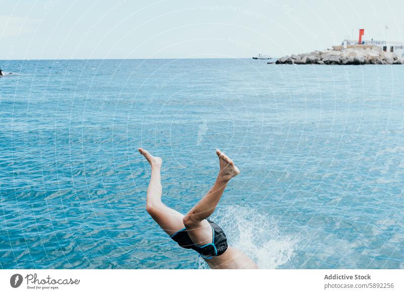 Eine Person taucht im Sommerurlaub fröhlich ins blaue Meer Feiertag MEER Sinkflug Mann platschen Wasser übersichtlich Himmel Gelassenheit Küste Küstenstreifen