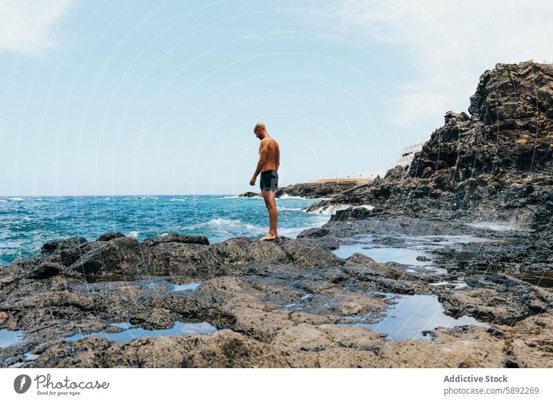 Mann erkundet felsige Küste an einem sonnigen Tag Meer Felsen MEER winken Natur Uferlinie Sommer Feiertag Barfuß Erkundung Abenteuer aquatisch Landschaft