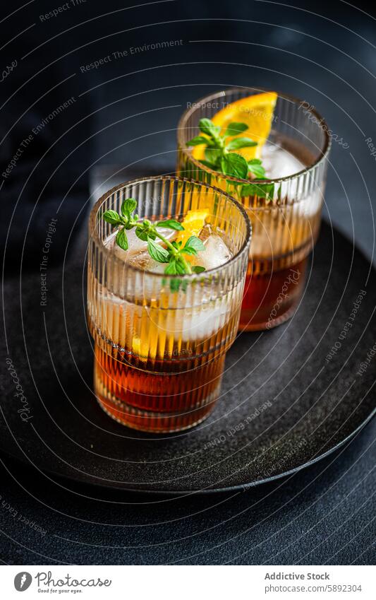 Eleganter Kirschlikör-Cocktail mit Tonic, Eis und frischer Minze Sommer Kirsche Likör orange Scheibe Blatt Glas Getränk trinken Erfrischung Alkohol Bar