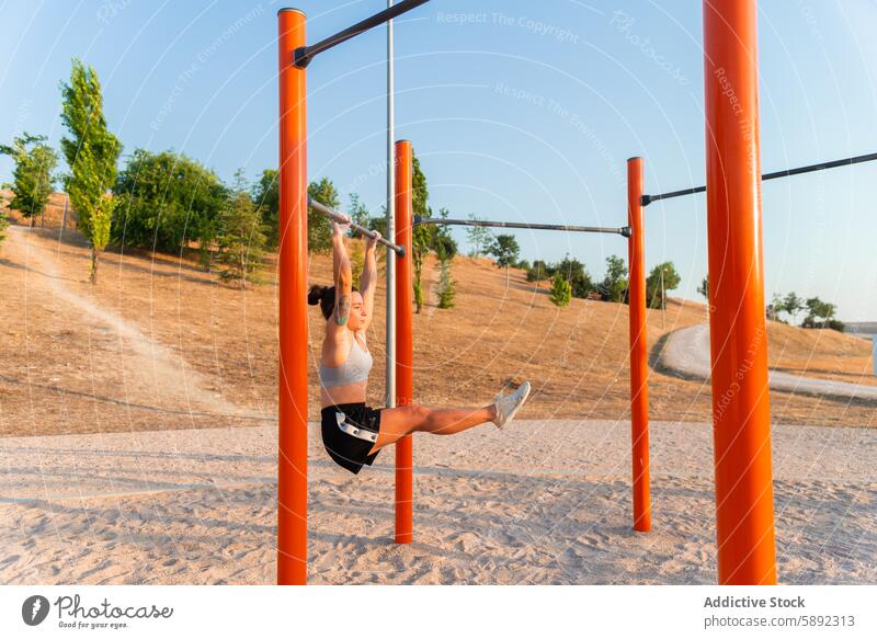 Frau trainiert im Sommer an einer Klimmzugstange im Freien Übung Fitness Training Beinheben hügelig Landschaft übersichtlich Tag jung Kleidung Stärke Gesundheit