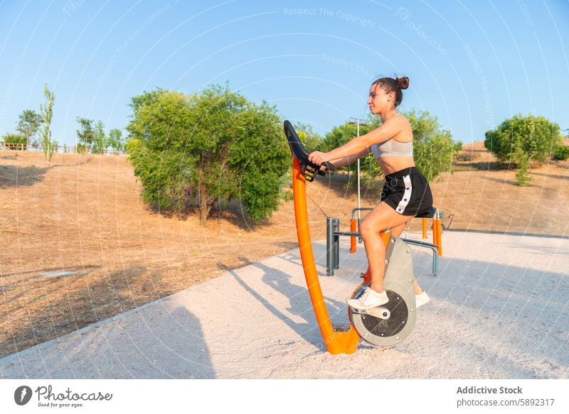 Junge Frau trainiert an Outdoor-Fitnessgeräten Übung im Freien Fitnessstudio Straße Fahrrad Training Gesundheit Sport aktiv Lifestyle Wellness jung Gerät