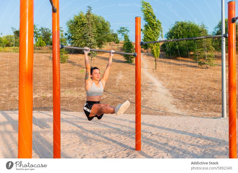 Junge Frau trainiert im Fitnessstudio im Freien im Park Übung Stärke Beweglichkeit horizontaler Balken Training Gesundheit Natur Sport Aktivität Krafttraining