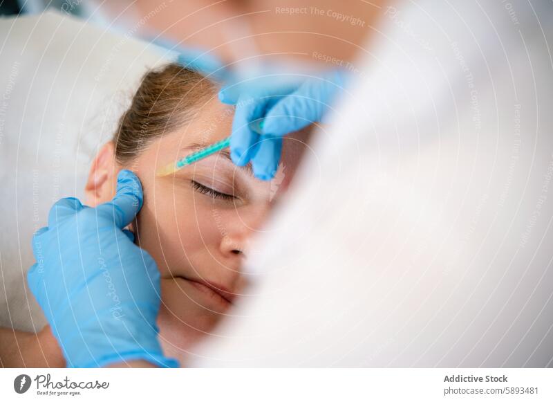 Physiotherapeutin gibt einem Kunden in der Klinik eine Gesichtsinjektion Klient geduldig Leckerbissen Gesichtsbehandlung Lügen Einspritzung Empfang Haut