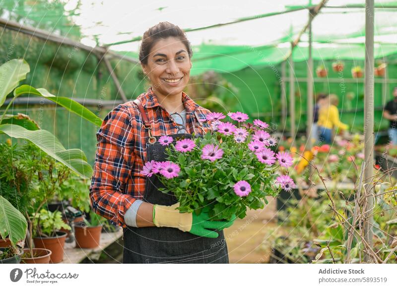 Fröhliche Gärtnerin mit Blumenstrauß Frau Lächeln Gewächshaus Gartenbau geblümt Pflanze Landwirt Blüte Blütezeit Flora Handschuh kultivieren frisch natürlich