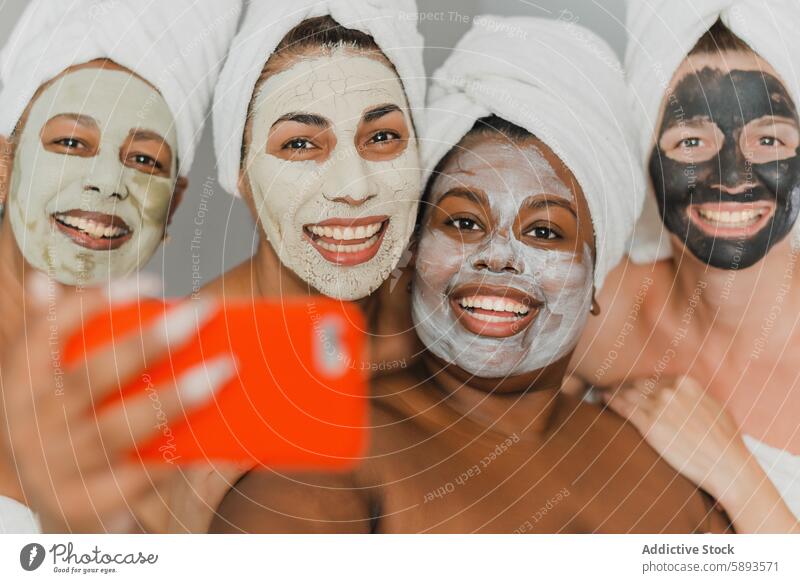 Multiethnische Frauen mit Gesichtsmasken machen ein Selfie Spa Lächeln Zusammensein Freundin Smartphone Mundschutz Menschengruppe