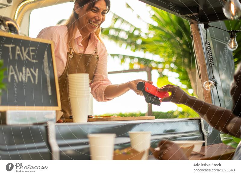 Fröhliche schwarze Frau beim Bezahlen eines Kaffees in einem Café Smartphone Gerät benutzend Apparatur Cappuccino Arbeit Browsen Kantine Mobile Latte