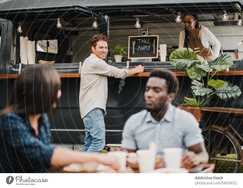 Multirassische Menschen essen an einem Imbisswagen im Freien - Fokus auf das Gesicht des Mannes in der Mitte Afrikanisch Bar Getränk Business Großstadt