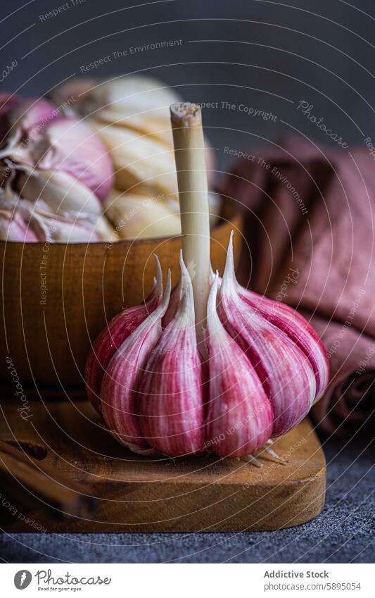 Künstlerische Darstellung von frischen Knoblauchzehen auf einem Holzbrett Bestandteil Essen zubereiten Küche hölzern Holzplatte organisch Nahaufnahme rustikal