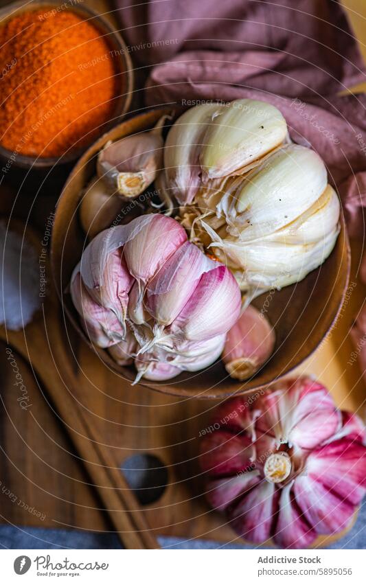 Ganzer Knoblauch in einer Schüssel und Gewürze in einem rustikalen Rahmen Schalen & Schüsseln hölzern kulinarisch Bestandteil Essen zubereiten Holztisch