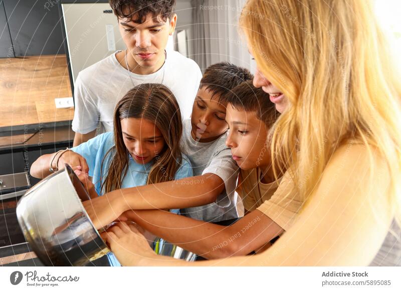 Drillinge beim gemeinsamen Kochen in einer modernen Küche Triplett Essen zubereiten Zusammenarbeit Teamwork Geschwisterkind Gießen Topf sonnig Familie heimwärts