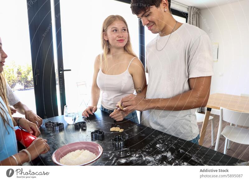 Die Familie backt gemeinsam in einer modernen Küche backen Essen zubereiten heimwärts Teamwork binden Partnerschaft Keks Teigwaren Vorbereitung lässig Lifestyle