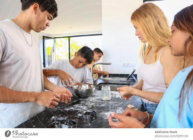 Drillinge backen zusammen mit ihren Geschwistern in der Küche Kekse Triplett Bruder Schwester Essen zubereiten Teigwaren Ausstechform Vorbereitung selbstgemacht