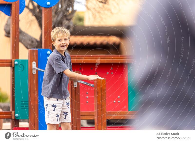 Junger Junge spielt auf einem bunten Spielplatz Struktur Kind im Freien Sommer spielen freudig Fröhlichkeit lässig Aktivität sonnig Tag Spaß Freizeit Park