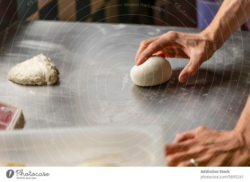 Nahaufnahme von Händen beim Kneten von Pizzateig auf einem Tisch Teigwaren kneten Hand Prozess Küche metallisch Oberfläche backen Essen zubereiten Lebensmittel