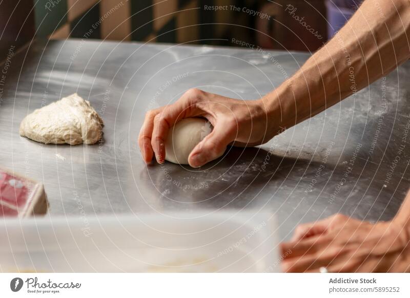 Hand knetet Teig auf einer Stahlplatte in einer Küche Pizza Teigwaren Kneten Küchenchef Vorbereitung Lebensmittel Essen zubereiten backen Restaurant Mahlzeit