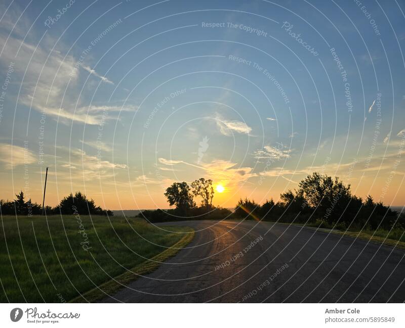 Sonnenaufgang spiegelt sich über der Straße, über einen Hügel hinweg Sonnenaufgang - Morgendämmerung Natur Landstraße Bäume im Hintergrund Hallo zum Morgen