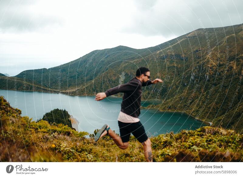 Mann läuft im Freien mit Blick auf einen malerischen See in Sao Miguel. rennen São Miguel Azoren Landschaft grün blau Wasser Natur Hügel Bewegung Fitness aktiv