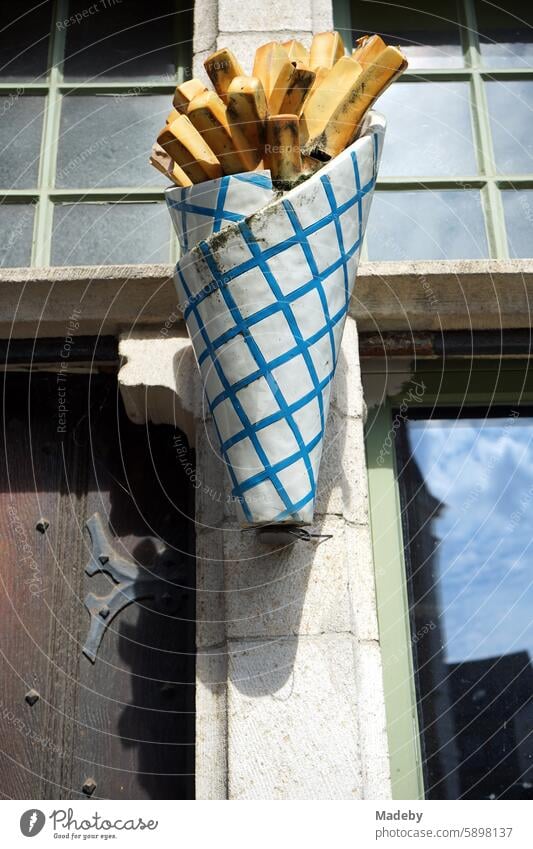 Überdimensionale Papiertüte mit Pommes Frites vor einem Imbiss in den Hassen der Altstadt von Gent in Ostflandern in Belgien Mittagszeit Fassade Naturfarben
