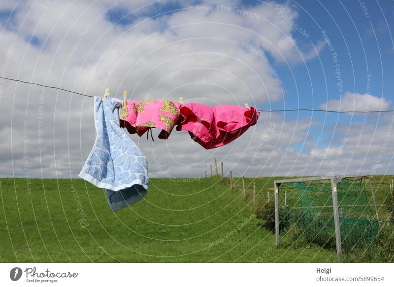 Hallig Gröde | flatternde Badewäsche auf der Leine Wäsche Badehose Handtuch Wäscheleine Wind windig Wiese Deich Fußballtor Himmel Wolken Sommer Natur