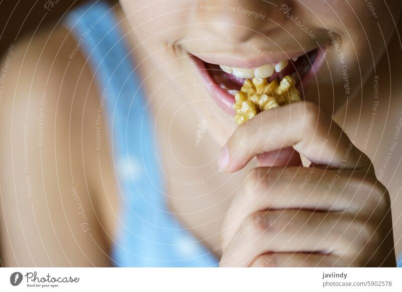 Crop unkenntlich Teenager-Mädchen essen gesunde Walnuss-Kernel Walnussholz Gesundheit Nut hungrig frisch Diät Lebensmittel Snack Protein Ernährung Offener Mund