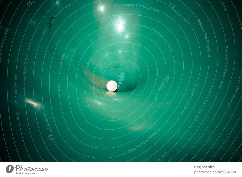 Der Rubel rollt in der Tonne und verschwindet im Loch. wegwerfen Ordnung entsorgen Geldmünzen hinein Rollenspiel grün spielerisch hineinsehen Weg