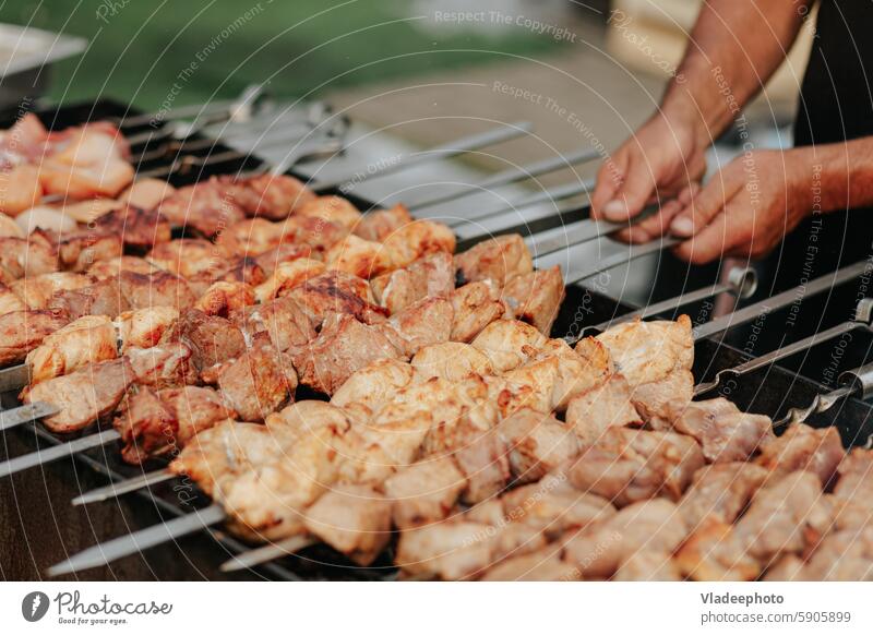 Braten von Schaschlik am Spieß im Schmortopf. Frisches rotes Fleisch für den Grill auf dem Feuer im Freien. Lebensmittel Barbecue Kebab Essen zubereiten