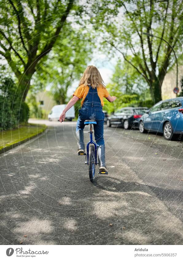 Kind fährt auf einem Einrad auf der Straße Fahrrad fahren Mädchen Fahrradfahren Kindheit Mobilität Wege & Pfade Bewegung Freizeit & Hobby sportlich Rad