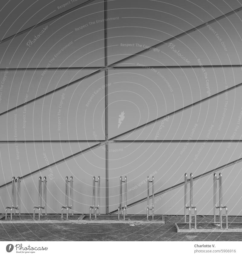 Leere Fahrradständer vor einer weißen, strukturierten Wand weiße Wand leer Struktur Außenaufnahme grau Menschenleer Strukturen & Formen Fassade Architektur