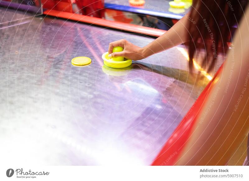 Anonyme Frau spielt Airhockey in einer Spielhalle Arkaden im Innenbereich Aktivität Freizeit Entertainment Fokus Sport Tisch puck spielen wettbewerbsfähig