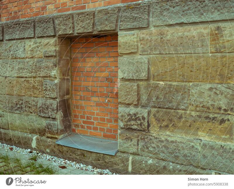 mit Backsteinen zugemauertes Fenster in einer Fassade aus Sandstein verschlossen Hauswand geschlossen verbarrikadiert alt Strukturen & Formen Mauer Stein