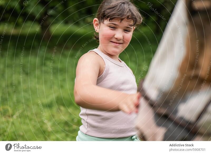 Junges Mädchen genießt die Zeit mit einem Pferd im Freien Interaktion berührend freudig Fröhlichkeit grün Natur Kind Tier Anschluss spielen sanft Sommer