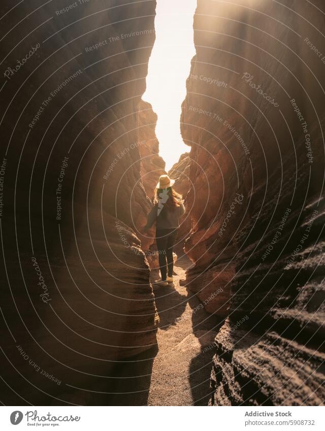 Person erkundet schmale Felspassage auf Lanzarote erkundend Felsen Durchgang Kanarische Inseln Sonnenlicht Abenteuer eng robust Texturen Natur wandern reisen