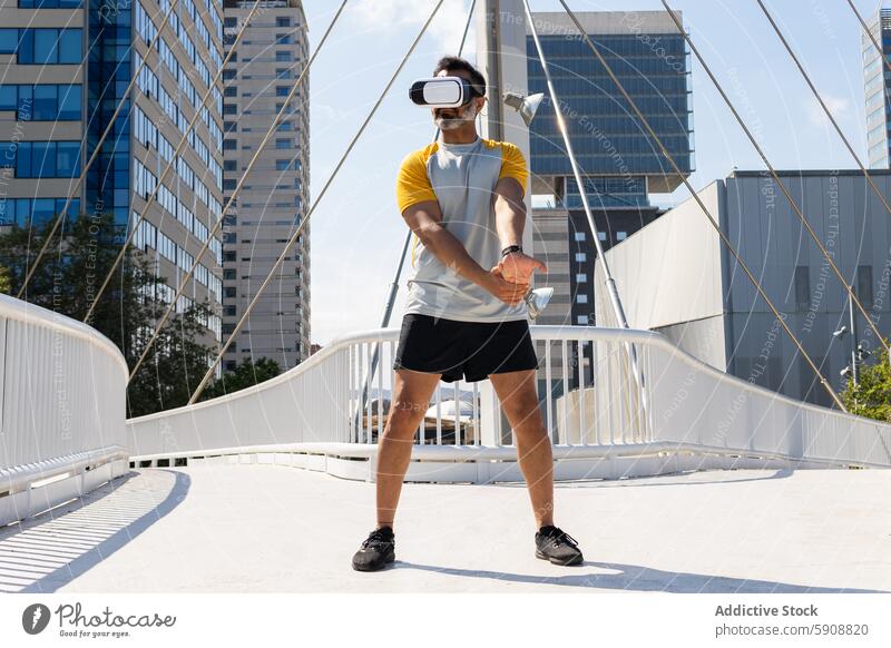 Mann mit Virtual-Reality-Headset auf einer städtischen Brücke Virtuelle Realität Großstadt im Freien Technik & Technologie Apparatur Gerät Sommer Sport Fitness