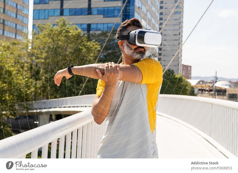 Mann mit Virtual-Reality-Headset im Freien in sonniger Umgebung Inder Virtuelle Realität Großstadt Brücke strecken Technik & Technologie Apparatur Sommer Sport