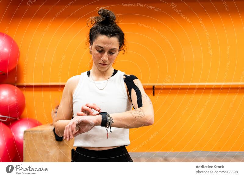 Junge Frau bereitet sich auf ihr Training im Fitnessstudio vor und überprüft ihren Fitness-Tracker Übung Sport Gesundheit Athlet Technik & Technologie Armband