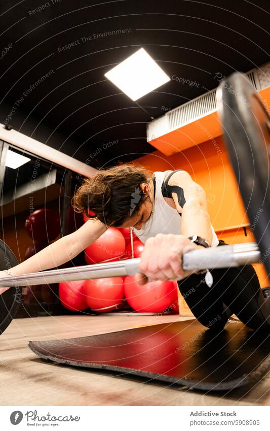 Junge Frau trainiert im Kraftdreikampf im Fitnessstudio Stärke Training Curl-Hantel Heben Gesundheit Sport Athlet Tatkraft Fokus stark intensiv Griff