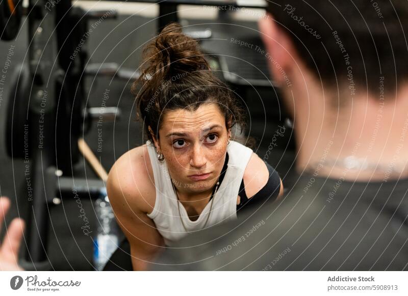 Intensive junge Frau konzentriert beim Kraftdreikampf Fitnessstudio Stärke Tatkraft Training Gesundheit Curl-Hantel Fokus intensiv Athlet Sport Muskel Gerät