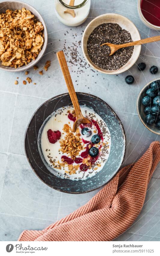 Gesundes Frühstück mit Joghurt, Beeren und Chiasamen in einer Schüssel. Zutaten, Draufsicht. Gesundheit Diät roh süß Dessert Frucht Löffel organisch weiß