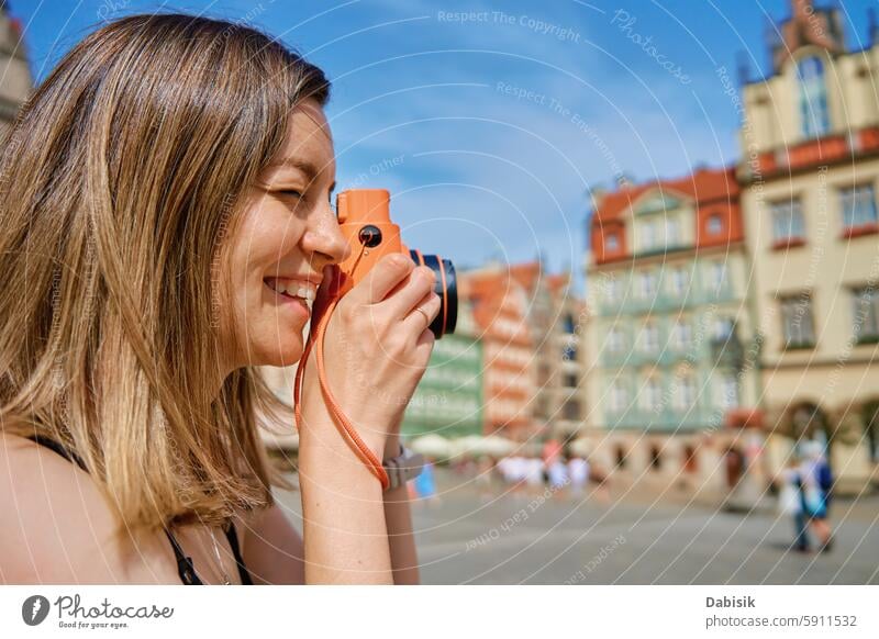 Junge Frau, die in einer europäischen Stadt Fotos macht Fotokamera reisen Tourismus Fotograf europäische Stadt historische Architektur Stadtplatz