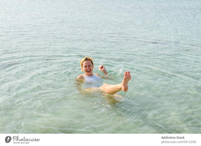 Fröhliche Frau spielt im klaren Wasser an einem italienischen Strand platschen Sommer Urlaub MEER Italienisch spielen Freude heiter schwimmen kristallklar