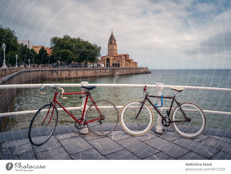 Radfahren an der Küste in Gijon mit Kirchenkulisse gijon Spanien Fahrrad Hafengebiet Reling iglesia de san pedro Fahrradfahren Küstenstadt reisen Tourismus