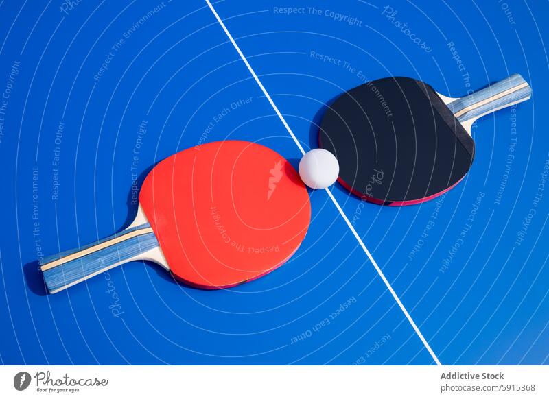 Tischtennisschläger und Ball auf einem blauen Tisch Tennis Paddel Sport Spiel Ping pong rot schwarz Gerät Konkurrenz spielen Freizeit Aktivität Übung