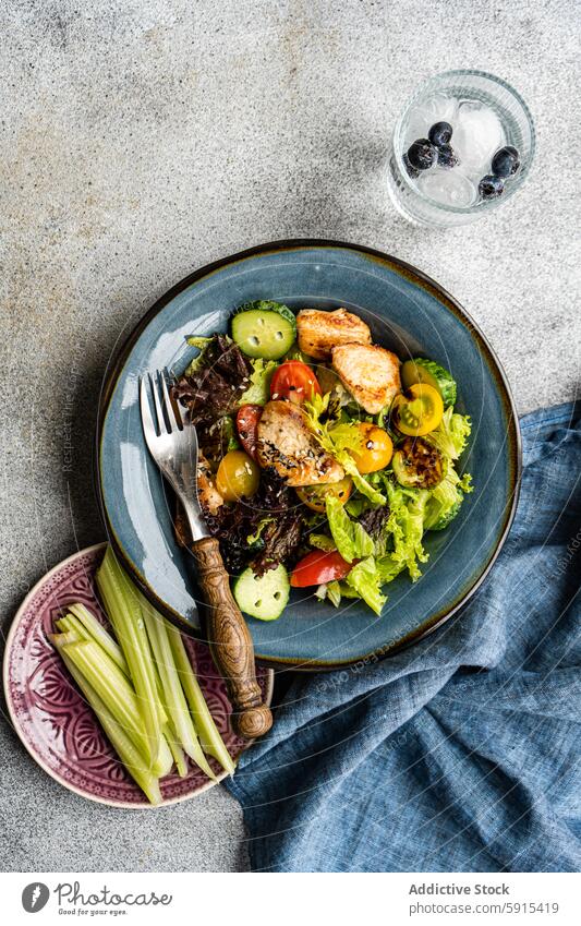 Draufsicht auf einen hausgemachten Gemüse-Hühnersalat Salatbeilage selbstgemacht Hähnchen Kirschtomate Salatgurke Paprika Sesamsamen nahrhaft Speise Mahlzeit