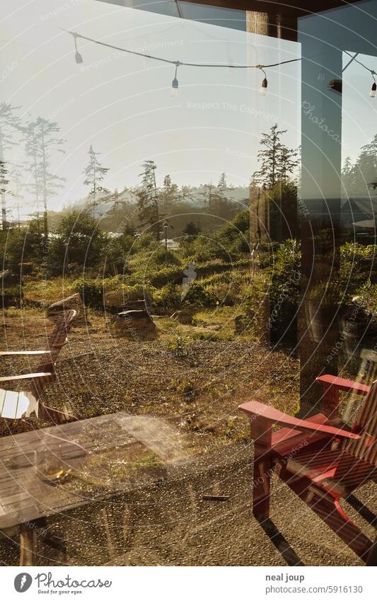 Blick durch die reflektierende Scheibe über eine Terrasse auf die Küste Westkanadas Urlaub Haus am Meer Ausblick Natur natürlich unberührt ruhig abgelegen