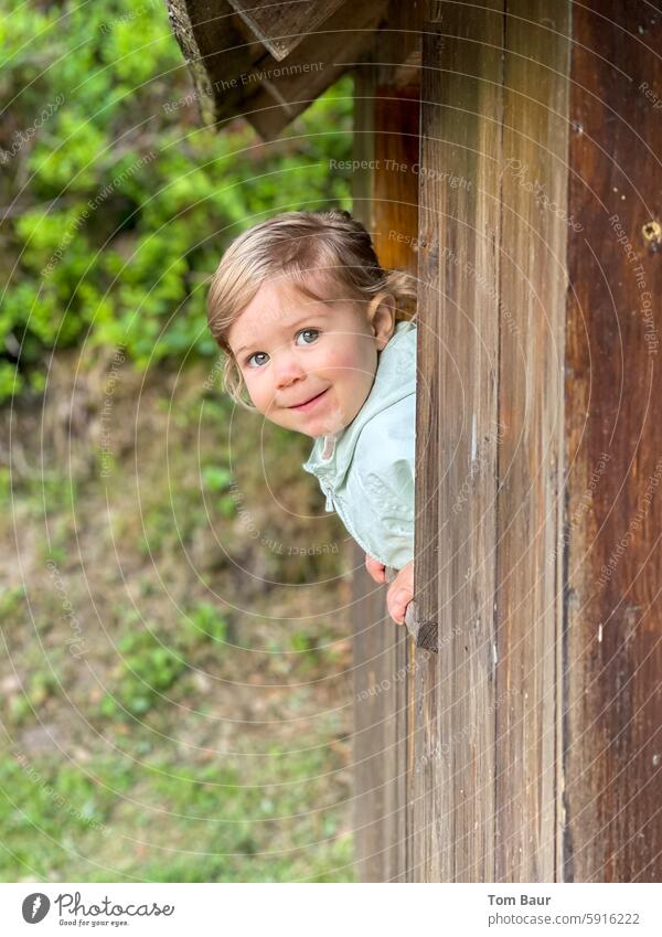 Kuckuck wer ist da an meinem Häuschen Mädchen süß schaut aus dem Fenster Spielplatz Blick aus dem Fenster Fensterblick Sommer Licht Kind Kindheit große Augen