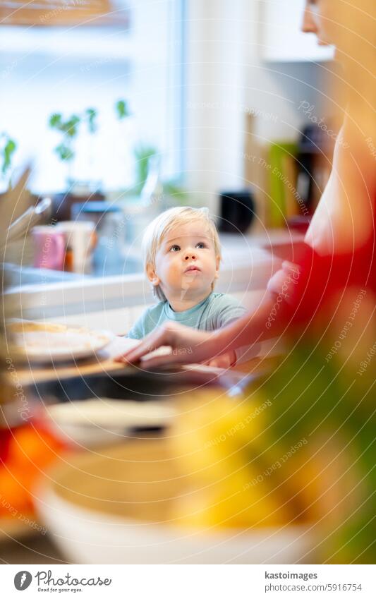 Mutter und kleines Kleinkind Baby Junge machen Pfannkuchen zum Frühstück zusammen in heimischen Küche. Familie, Lebensstil, häusliches Leben, Lebensmittel, gesunde Ernährung und Menschen Konzept.