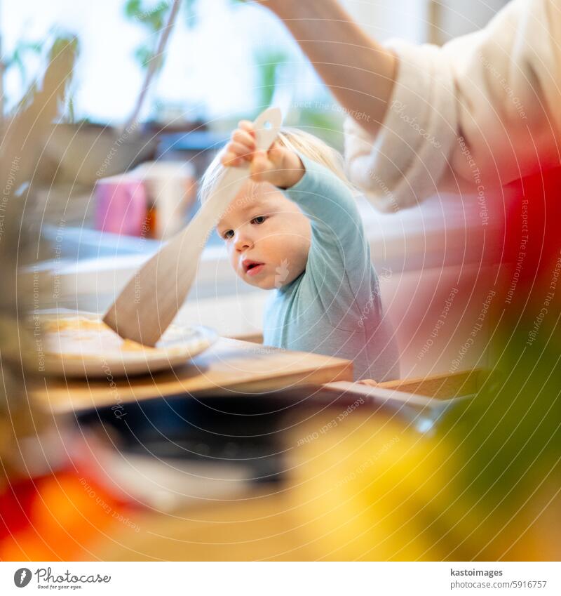 Mutter und kleines Kleinkind Baby Junge machen Pfannkuchen zum Frühstück zusammen in heimischen Küche. Familie, Lebensstil, häusliches Leben, Lebensmittel, gesunde Ernährung und Menschen Konzept.