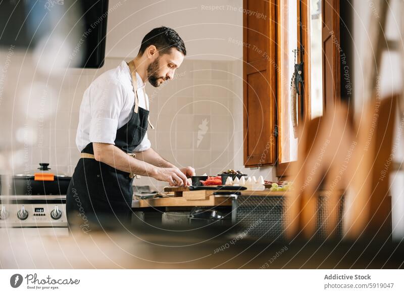 Privatkoch bei der Zubereitung einer Mahlzeit in der heimischen Küche Küchenchef heimwärts professionell männlich Essen zubereiten vorbereitend Schneiden Gemüse