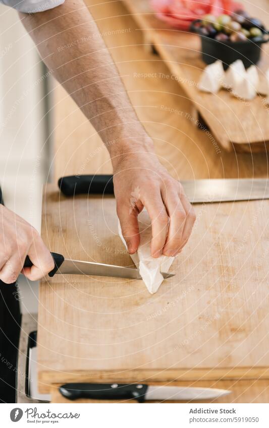 Privatkoch bei der Zubereitung von Speisen auf einem Schneidebrett Küchenchef Essen zubereiten Messer Hand männlich Vorbereitung Lebensmittel kulinarisch