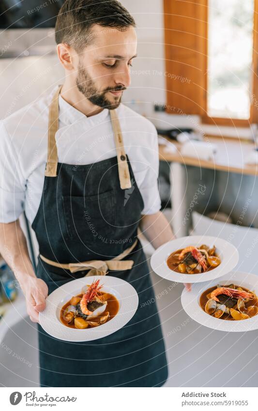 Privatkoch serviert Meeresfrüchtegerichte in einer modernen Küche Speise Teller Feinschmecker Schürze Dienst sonnenbeschienen Fokus professionell kulinarisch